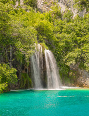 Long exposure waterfall during the day. green forest and rocky mountain. summer time at Plitvice Lakes in Croatia. crystal clear blue water