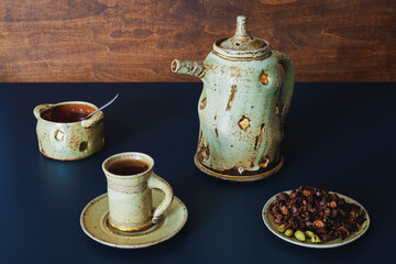 Cups with cascara beverage with honey in unique ceramic tea set.