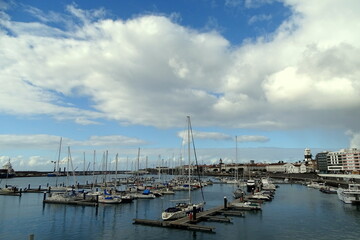 Fototapeta na wymiar City Ponta Delgada, harbor with sailing boats, blue ocean and sky.