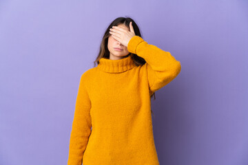 Young caucasian woman isolated on purple background covering eyes by hands. Do not want to see...