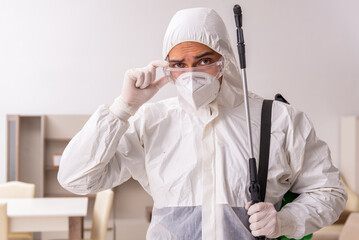 Fototapeta premium Young male contractor doing pest control at home
