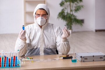 Young male chemist working at the lab during pandemic