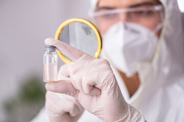 Young male chemist working at the lab during pandemic
