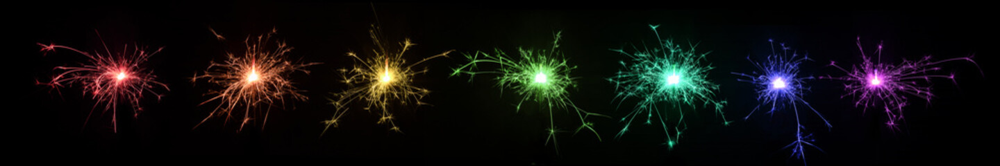 Row of colored sparklers on a black background. Colors of rainbow.