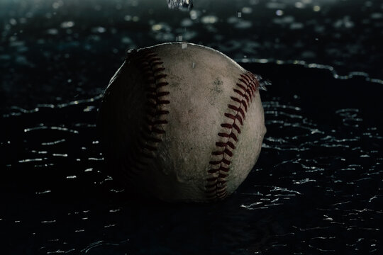 Moody baseball background with used ball from game closeup in water.
