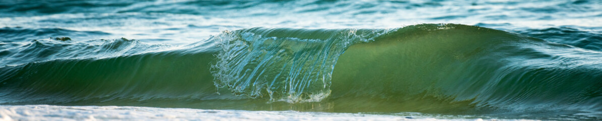 Banner of a sea wave breaking creating a tube.