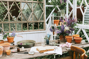 white retro terrace in the summer garden decorated with vintage details and bouquets of wildflowers lilac lupines with retro pots