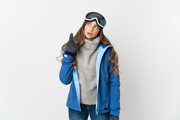 Skier girl with snowboarding glasses isolated on white background thinking an idea pointing the finger up