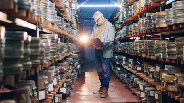 Male archivist is keeping the record of vintage film tapes