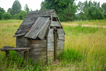 Old wooden well in the meadow