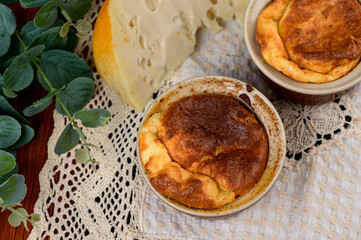 French baked cheese souffle in rameken on wood table