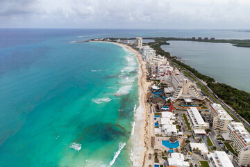 The ocean shore on which the houses are located has a different infrastructure. Small town. Blue ocean water. Green spaces. Resting-place. View from above. Aerial photography.