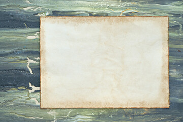Mockup, copy-space on aged patchment, beige paper page. Flat lay on aged textured painted green brown background. Abstract textured cracked background.