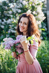 portrait of a beautiful brunette woman in a lilac dress with lilac flowers