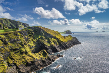 Tall Kerry Cliffs illuminated by sunlight and a view on Skellig Michael island. Star Wars film...