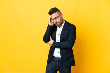 Businessman over isolated yellow background with headache