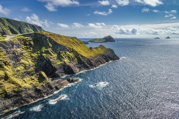 Tall Kerry Cliffs and a view on silhouette of Skellig Michael island in a distance. Star Wars film...