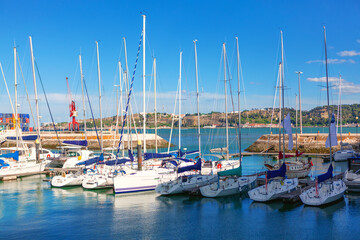 Fototapeta na wymiar View of a marina in Lisbon . Harbor with luxury yachts . Boat masts against sky 