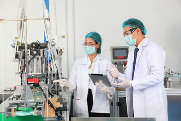 Production engineer with face mask working in factory , Qc engineer checking mask for good quality , Concept of protective action and quarantine to stop spreading of Coronavirus Disease 2019