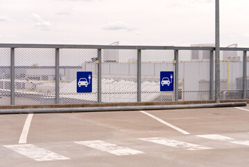 Symbol of an electric car charging place on the parking area in shopping center. Estonia, Tallinn