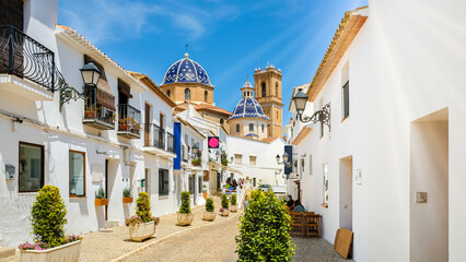 Street of Altea old town in Spain. Beautiful village with white houses and blue domed church Our...