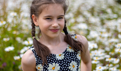 portrait of a girl in gymnasts black leotard with chamomile wild white flowers in the background