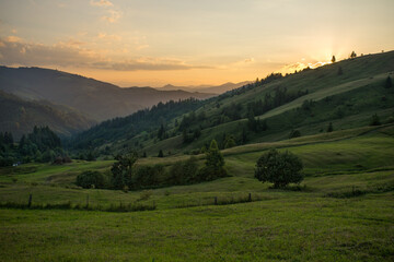 Fototapeta na wymiar Country rural landscape with orange evening sky, haycocks and fields