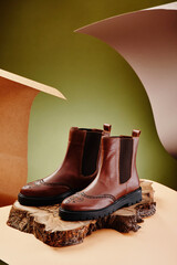 Brown leather chelsea boots made of genuine leather in classic style on a wooden cut. Close-up....