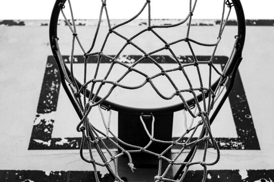 Basketball hoop in urban courtyard, black and white photo.