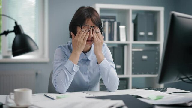 Office worker massaging eyes
