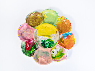 acrylic paint palettes and abstract pictures arranged on white background