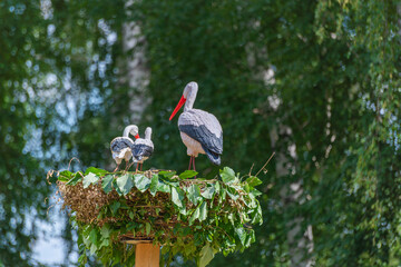 Stork with chicks in the nest. Plastic.