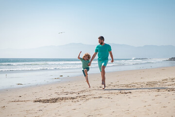Father and son running on beach. Dad and child playing outdoor. Happy family concept.