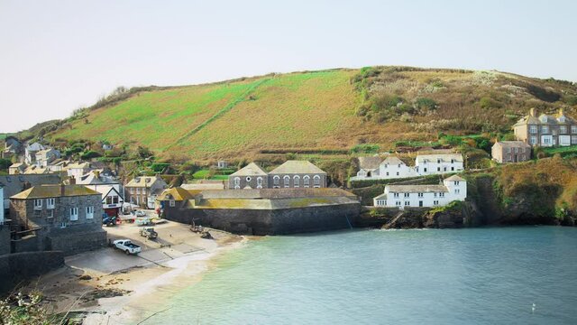 Port Isaac, small fishing village, Atlantic coast of north Cornwall, England. Porthysek - rocky scenic views with crystal clear transparent waters, green lands and beautiful old English houses in 4K.