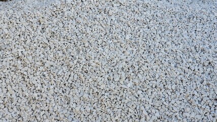 Small white decorative stones. For indoor and outdoor areas, gardens, borders, vases, street, construction. Background, texture, banner.