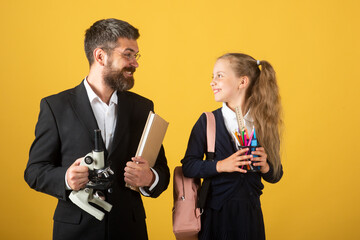 Schoolkid and a teacher on studio background. Portrait of tutor with school girl.