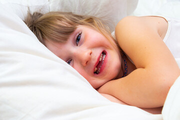 little girl with pet cat in bed