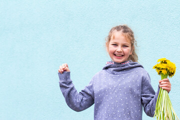 Little pretty schoolgirl reading a book sitting on the street