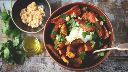Baked carrot bowl with white cheese, cilantro and peanuts. Healthly food. Vegetarian lunch.