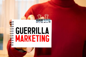 Text sign showing guerilla marketing. The text is written on a small wooden blackboard.