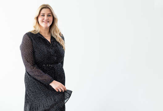 Overweight Beauty. Body Positive. Plus Size Clothing. Obesity Self-acceptance. Confident Happy Carefree Smiling Curvy Woman In Elegant Black Dress Isolated On White Copy Space Background.