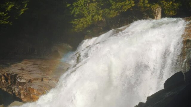 SLOW-MO waterfall on yellow rocks with a faint rainbow