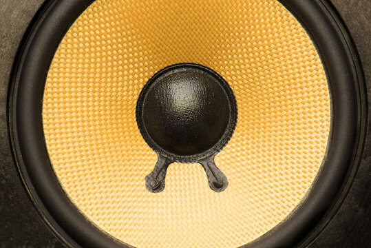 Close up of bare audio speakers with amber colored fiber glass or aramid fiber cone.