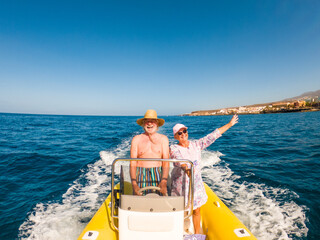 Beautiful and cute couple of seniors or old people in the middle of the sea driving and discovering...