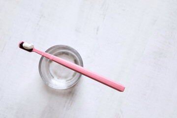 pink toothbrush with toothpaste, top view, copy space, dental hygiene