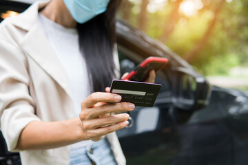 business woman using smartphone and credit card for shopping online in the car. Business new normal concept after covid-19 coronavirus outbreak.