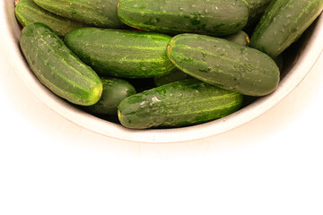 Cucumbers in bowl on white background