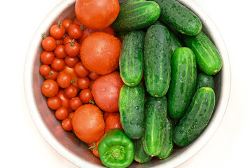 Bowl of vegetables with green cucumbers and red tomatoes