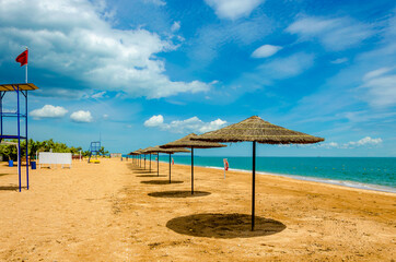 A row of umbrellas from the sun on the beach near the sea.