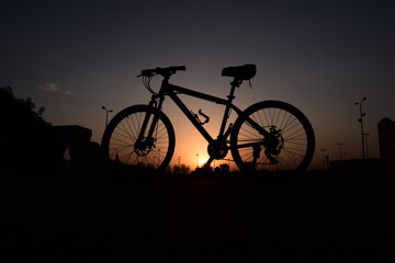 Fototapeta na wymiar silhouette of a bicycle by the roadside in the morning